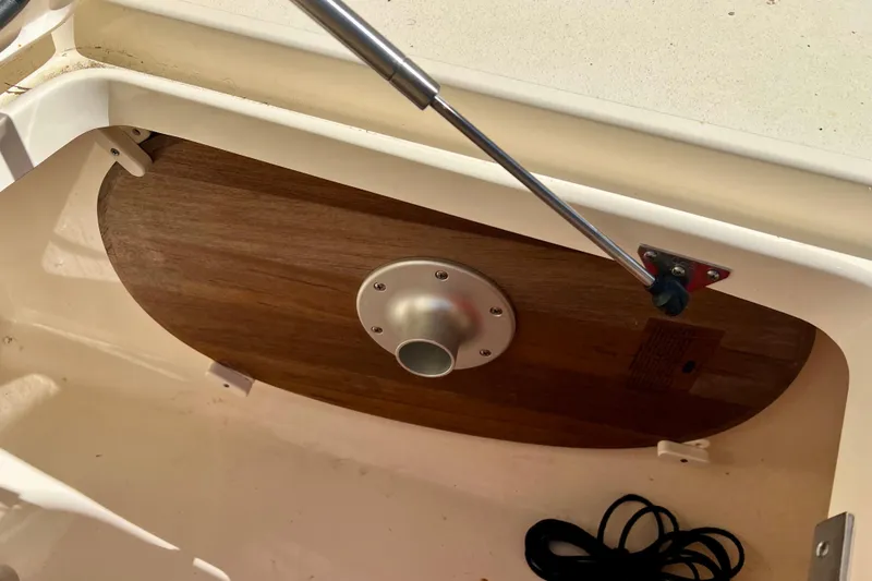 Slide: The Image of 2024 Scout 277 LXF boat compartment with wooden panel and metal fixture. - 19