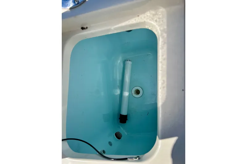 Slide: The Image of Livewell compartment in 2024 Scout 277 LXF boat, featuring a clean, blue interior. - 20