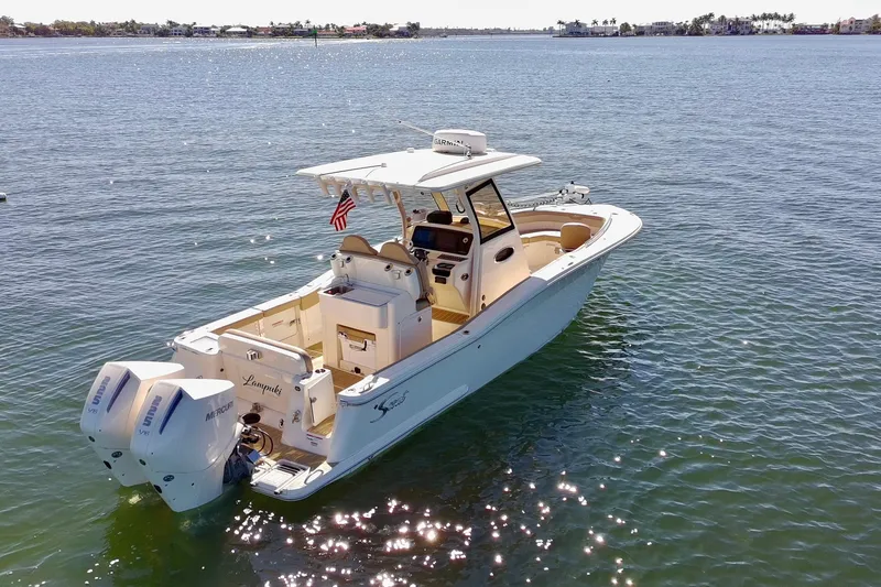 Slide: The Image of 2024 Scout 277 LXF boat on calm water, featuring dual Mercury engines. - 5