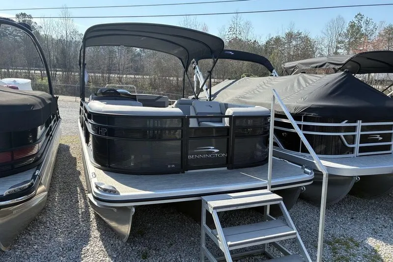 The Image of 2022 Bennington 22 SSBX pontoon boat with canopy, parked on gravel. - 1