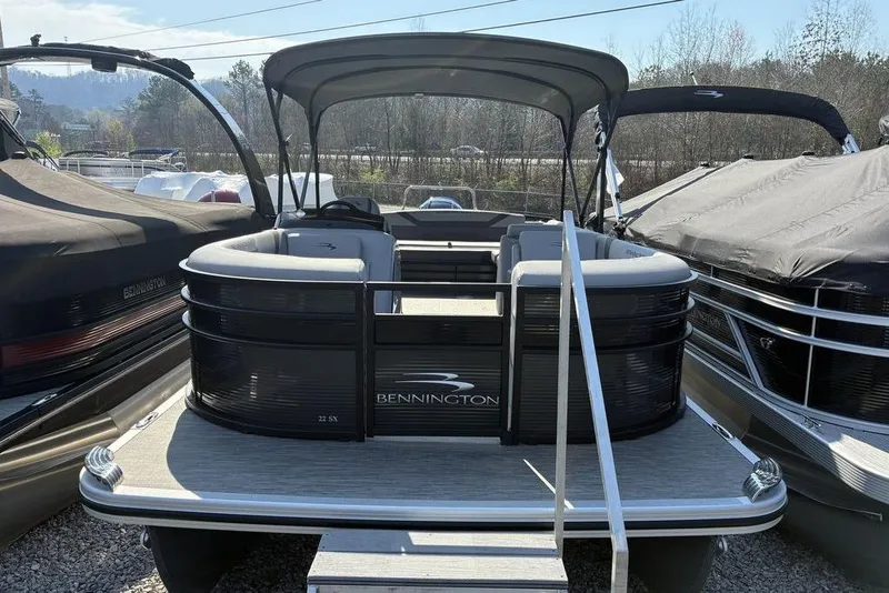 Slide: The Image of 2022 Bennington 22 SSBX pontoon boat with canopy, docked outdoors. - 3