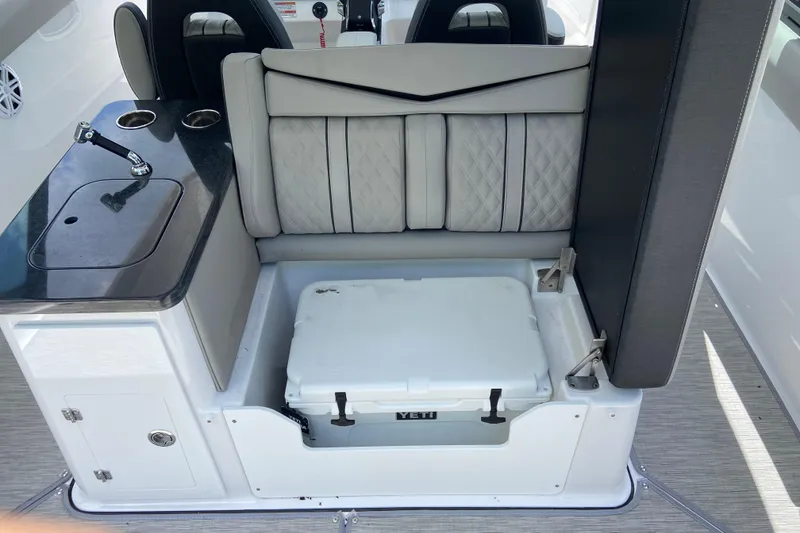 Slide: The Image of Luxury seating and kitchenette on 2026 Monterey Elite 30 OB boat, featuring integrated cooler storage. - 12