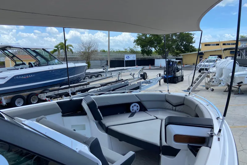 Slide: The Image of 2026 Monterey Elite 30 OB boat with spacious seating and modern design at a marina. - 37