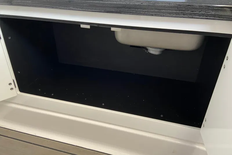 Slide: The Image of Open storage compartment under sink in 2026 Monterey Elite 30 OB boat. - 46