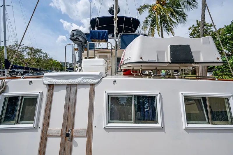 Slide: The Image of Grand Banks 46 Classic 1990 yacht with windows and equipment, docked under palm trees. - 10