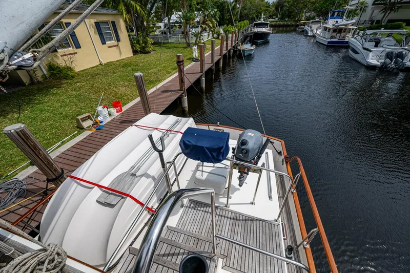 Slide: The Image of 1990 Grand Banks 46 Classic yacht docked at a serene marina with lush surroundings. - 11