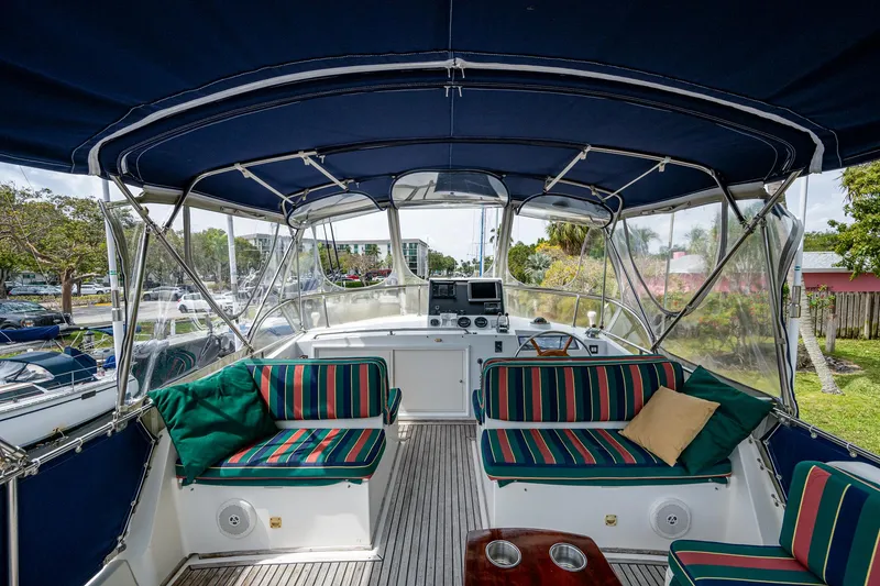 Slide: The Image of 1990 Grand Banks 46 Classic yacht interior with striped seating and navigation equipment. - 13