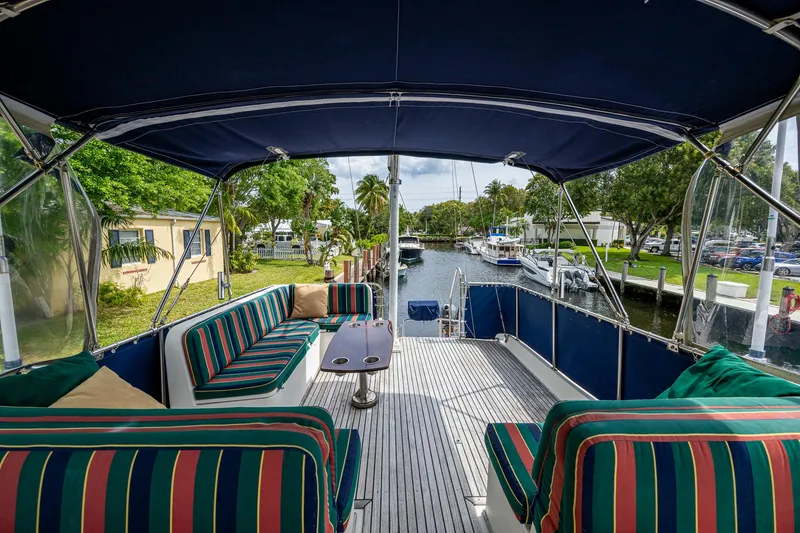Slide: The Image of Grand Banks 46 Classic 1990 yacht with striped seating, docked by a scenic canal. - 14