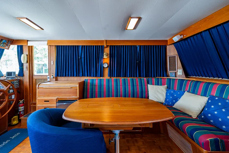 Slide: The Image of Interior of 1990 Grand Banks 46 Classic yacht with wooden table and striped seating. - 22