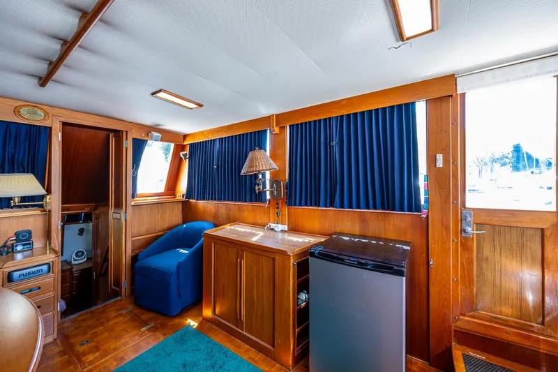 Slide: The Image of Interior of 1990 Grand Banks 46 Classic yacht with wood paneling and blue curtains. - 25