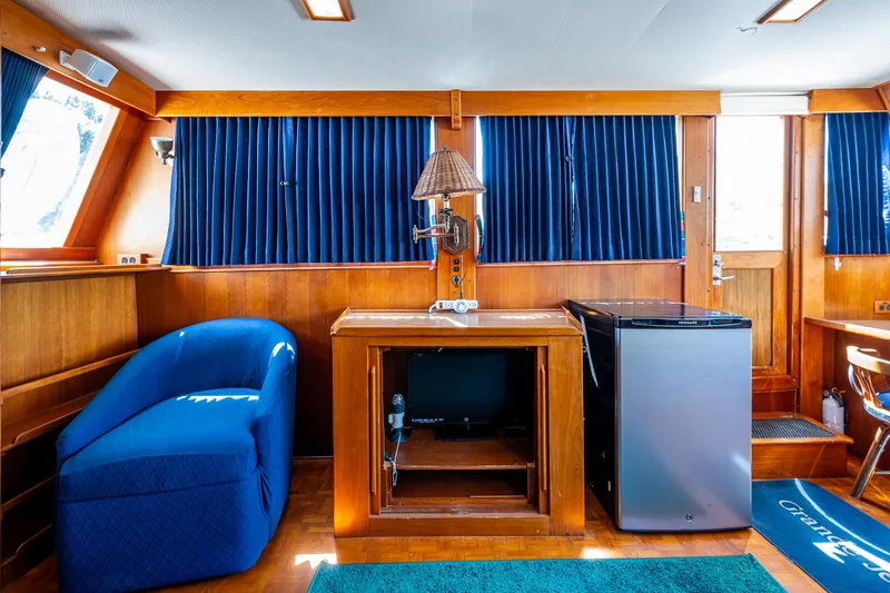 Slide: The Image of Interior of 1990 Grand Banks 46 Classic yacht with blue seating and mini fridge. - 26