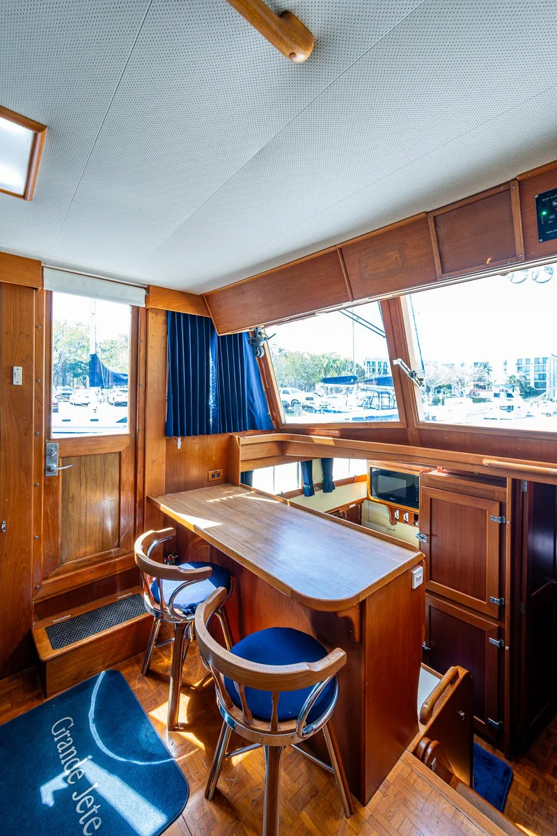 Slide: The Image of 1990 Grand Banks 46 Classic yacht interior with wooden furnishings and large windows. - 28