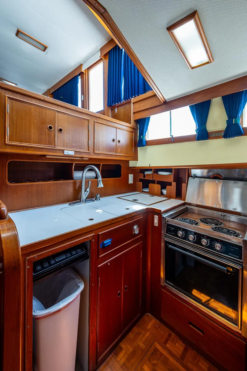 Slide: The Image of 1990 Grand Banks 46 Classic yacht kitchen with wood cabinetry and modern appliances. - 34