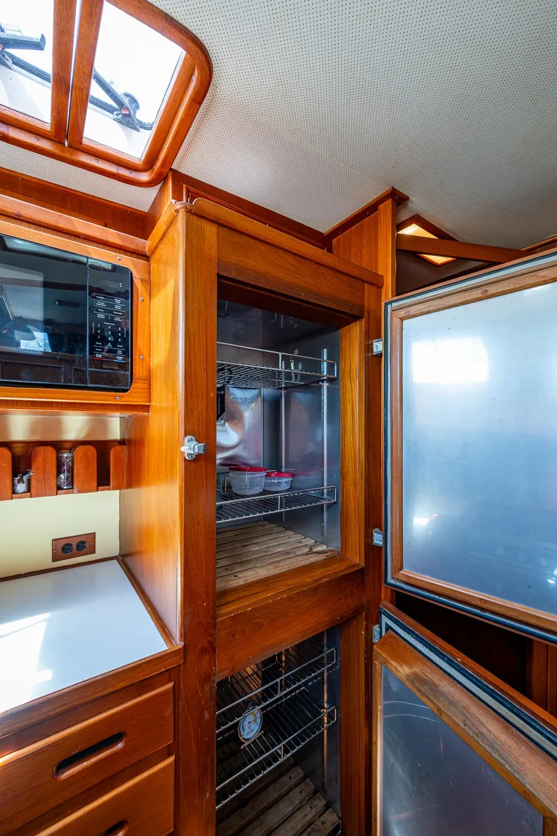 Slide: The Image of Interior of 1990 Grand Banks 46 Classic yacht with wooden cabinetry and open refrigerator. - 37