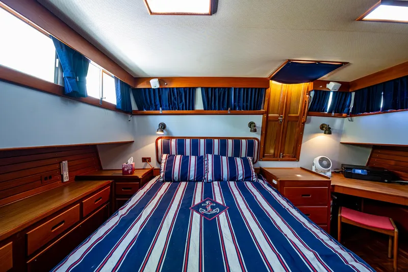 Slide: The Image of Luxurious cabin interior of a 1990 Grand Banks 46 Classic yacht with striped bedding. - 41