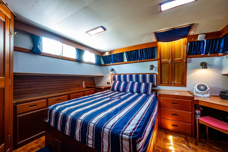 Slide: The Image of Luxurious cabin interior of 1990 Grand Banks 46 Classic yacht with striped bedding. - 42