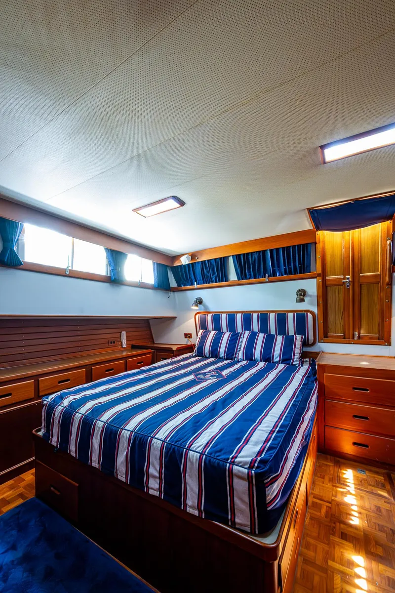 Slide: The Image of Luxurious cabin interior of 1990 Grand Banks 46 Classic yacht with striped bedding. - 43