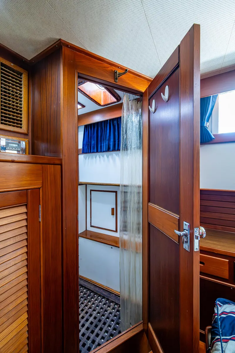 Slide: The Image of Interior of 1990 Grand Banks 46 Classic yacht, featuring wooden cabinetry and a shower area. - 45