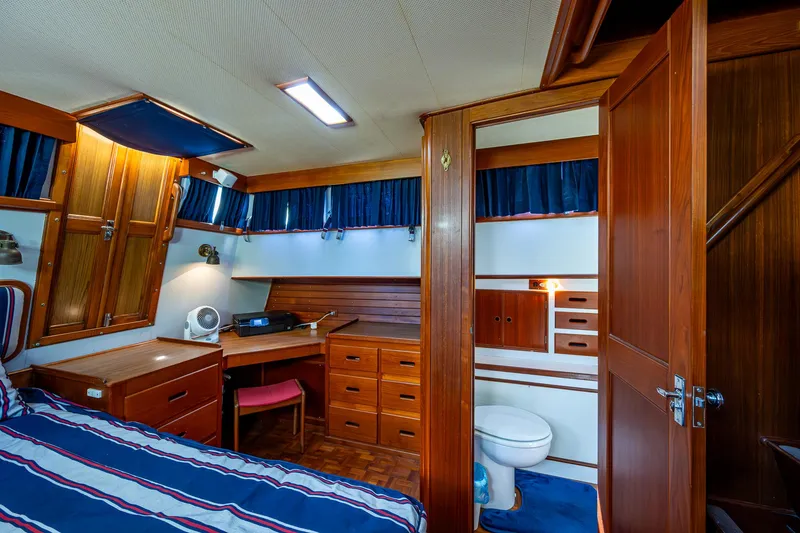 Slide: The Image of Cabin interior of 1990 Grand Banks 46 Classic yacht with wood furnishings and striped bedding. - 47