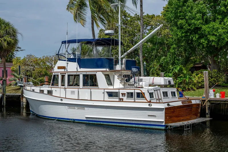 Slide: The Image of 1990 Grand Banks 46 Classic yacht docked by lush greenery and palm trees. - 5