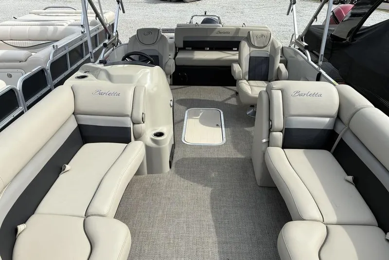 Slide: The Image of 2021 Barletta C22UC pontoon boat interior with beige seating and steering console. - 5