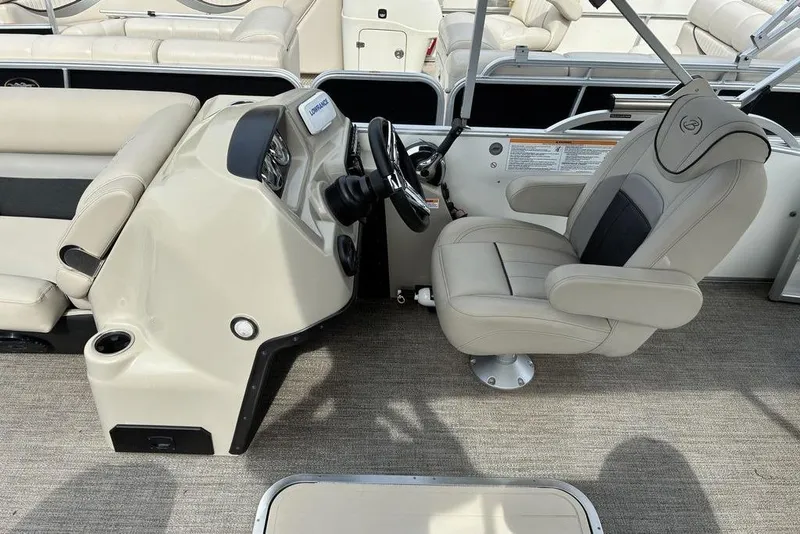 Slide: The Image of Captain's seat and helm of 2021 Barletta C22UC pontoon boat, featuring beige upholstery. - 6
