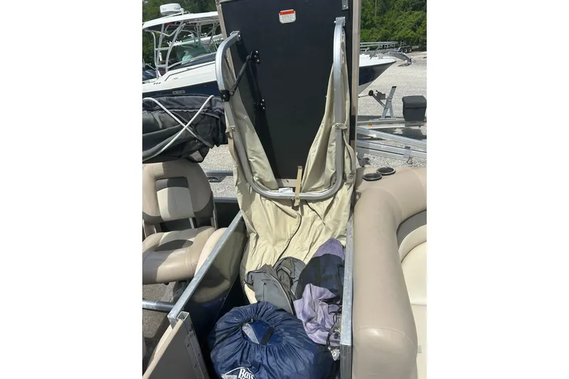 Slide: The Image of 2015 Sun Tracker Party Barge 22 Tritoon interior with storage compartment open. - 12