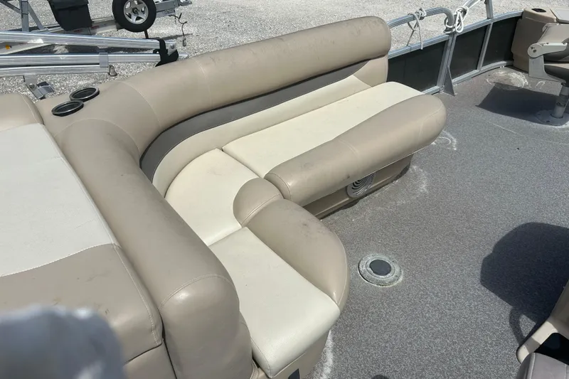 Slide: The Image of 2015 Sun Tracker Party Barge 22 Tritoon interior with beige seating and cup holders. - 14