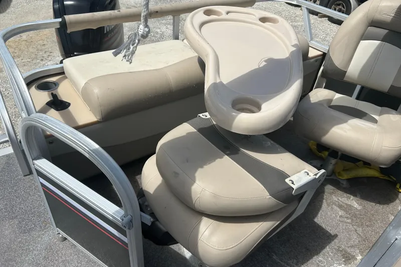 Slide: The Image of 2015 Sun Tracker Party Barge 22 Tritoon interior with beige seating and cup holders. - 18