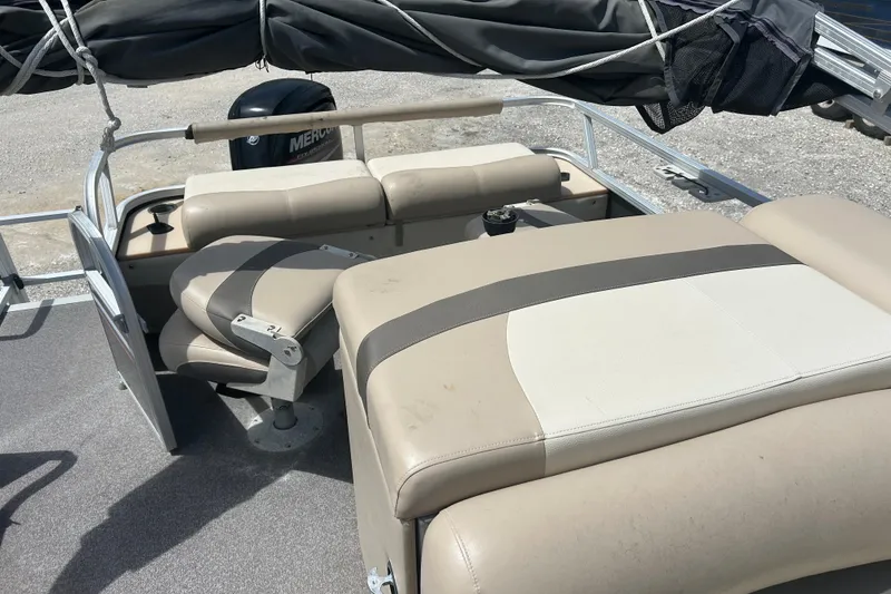 Slide: The Image of 2015 Sun Tracker Party Barge 22 Tritoon interior with beige seating and boat cover. - 21