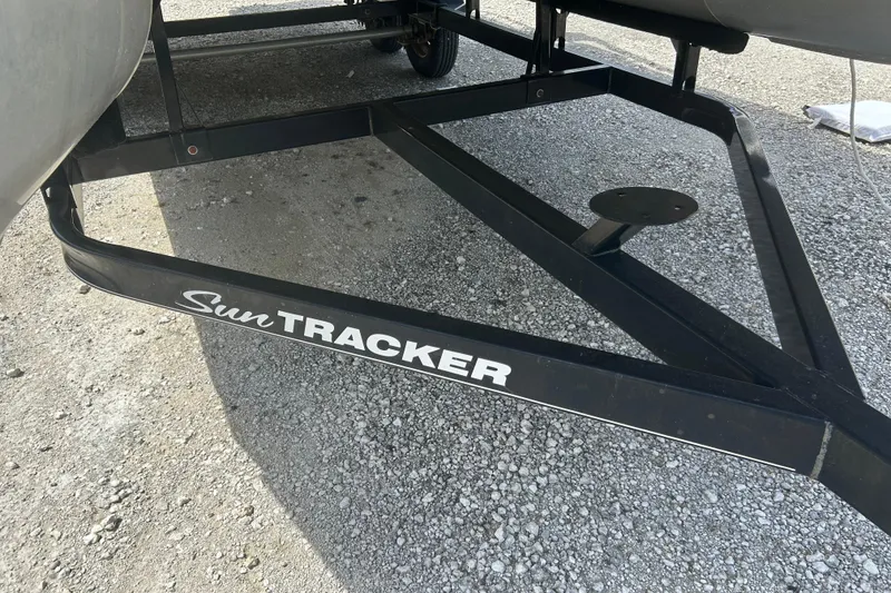Slide: The Image of 2015 Sun Tracker Party Barge 22 Tritoon trailer on gravel surface. - 22