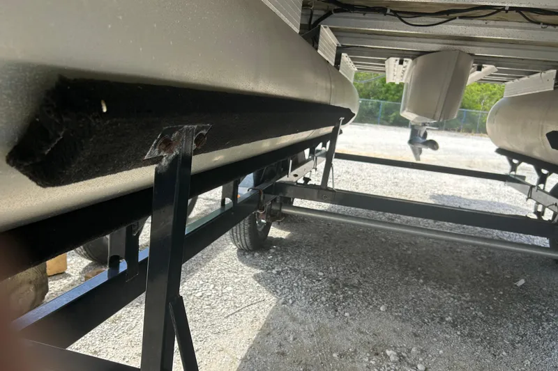 Slide: The Image of Underneath view of a 2015 Sun Tracker Party Barge 22 Tritoon on a trailer. - 23