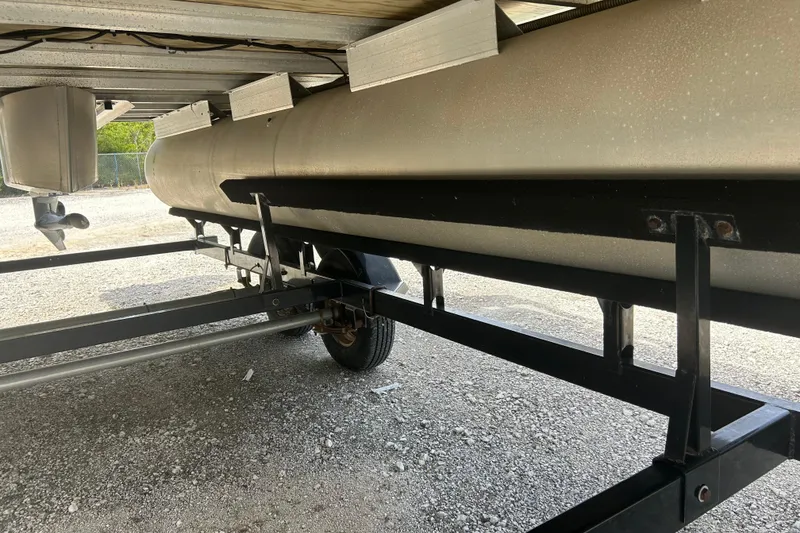 Slide: The Image of Underneath view of a 2015 Sun Tracker Party Barge 22 Tritoon on a trailer. - 24