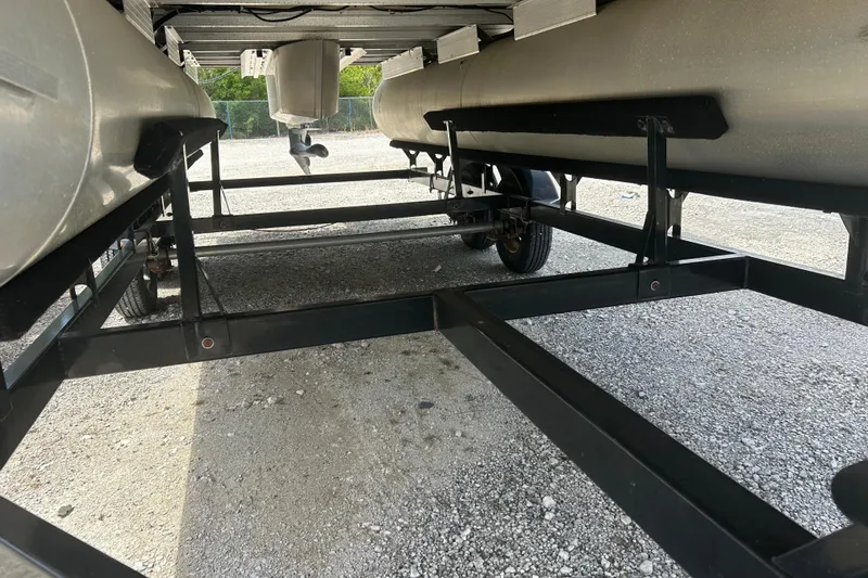 Slide: The Image of Underneath view of a 2015 Sun Tracker Party Barge 22 Tritoon on a trailer. - 25