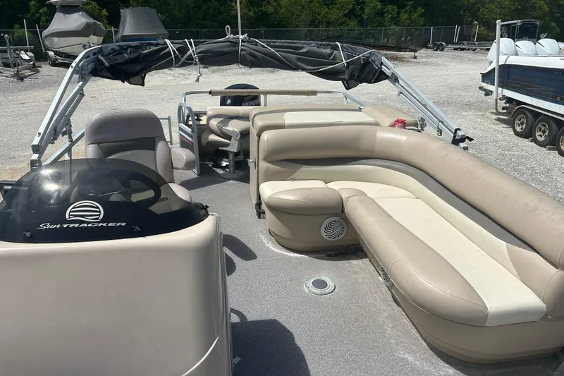 Slide: The Image of 2015 Sun Tracker Party Barge 22 Tritoon with spacious seating and canopy, parked outdoors. - 8