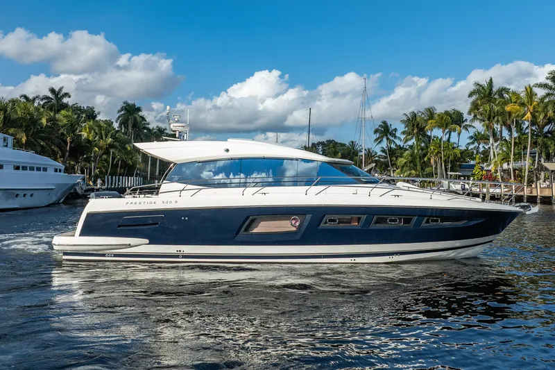 The Image of 2013 Prestige 500S yacht cruising on a sunny day with palm trees in the background. - 1