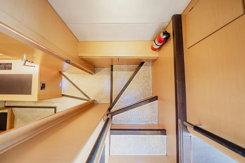 Slide: The Image of Staircase inside 2013 Prestige 500S yacht with wooden finish and fire extinguisher. - 17
