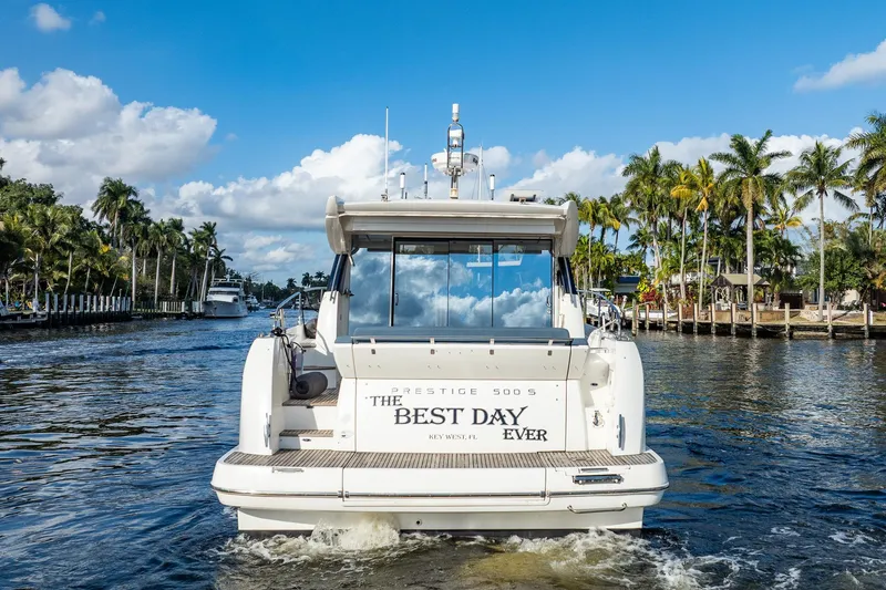 Slide: The Image of Prestige 500S yacht cruising on a sunny day, surrounded by palm trees and blue skies. - 3