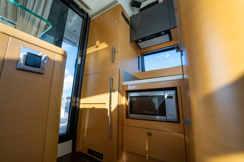 Slide: The Image of Modern kitchen interior of 2013 Prestige 500S yacht with microwave and wooden cabinetry. - 8