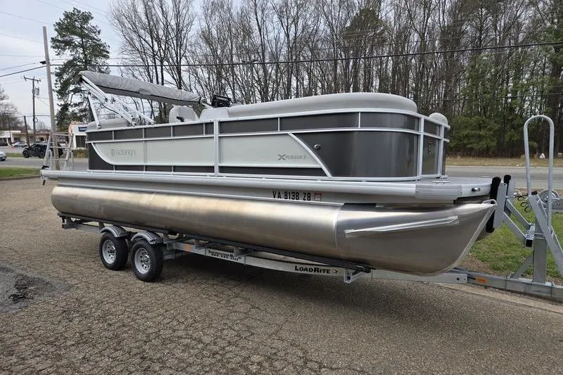 The Image of 2025 Godfrey Xperience 2286 SBX Sport Tube pontoon boat on trailer, parked outdoors. - 1