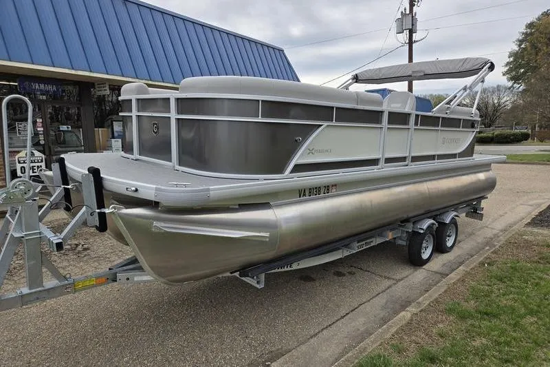 Slide: The Image of 2025 Godfrey Xperience 2286 SBX Sport Tube pontoon boat on trailer, parked outdoors. - 5