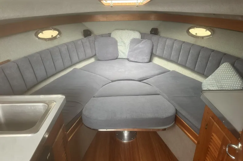 Slide: The Image of Interior of a 1985 Tiara 25 boat with cushioned seating and wooden accents. - 12