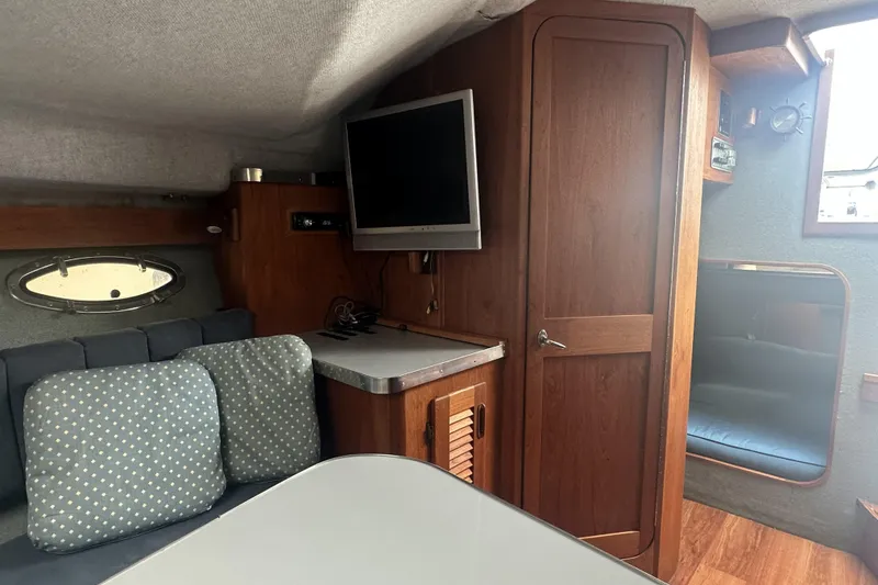 Slide: The Image of Interior of a 1985 Tiara 25 boat with wood paneling and seating area. - 15