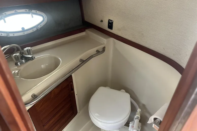Slide: The Image of Compact bathroom in a 1985 Tiara 25 boat with sink and toilet. - 16