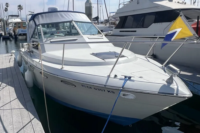 Slide: The Image of 1985 Tiara Yachts 2700 Continental docked, featuring a flag. - 3