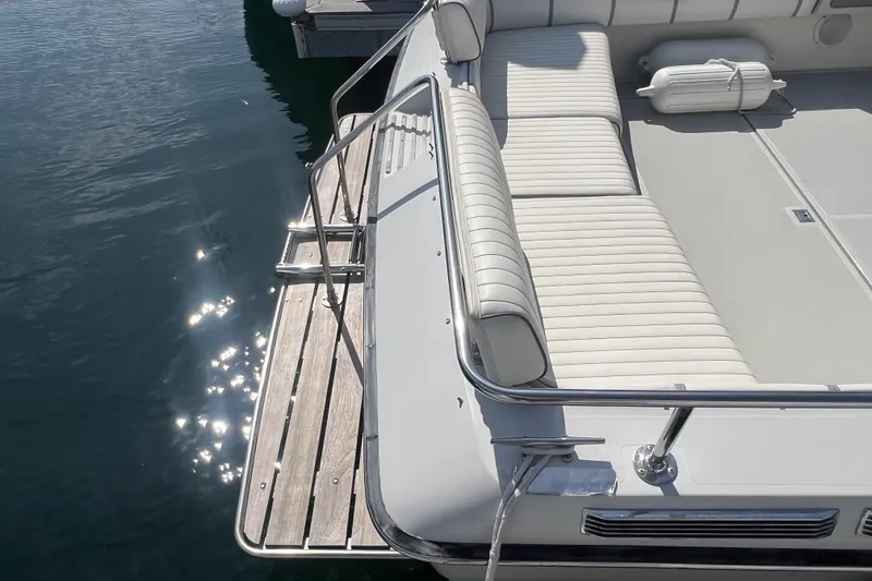 Slide: The Image of 1985 Tiara 25 boat with white seating and wooden swim platform. - 6