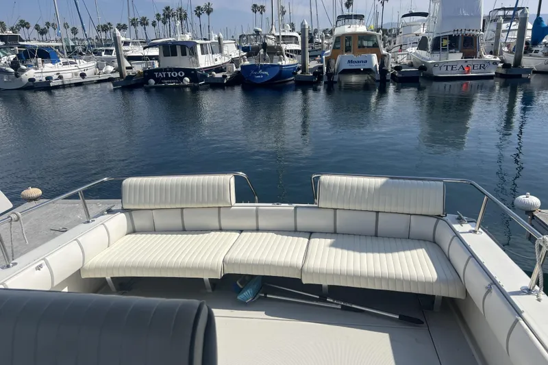 Slide: The Image of 1985 Tiara 25 boat interior with white seating, docked at a marina. - 7
