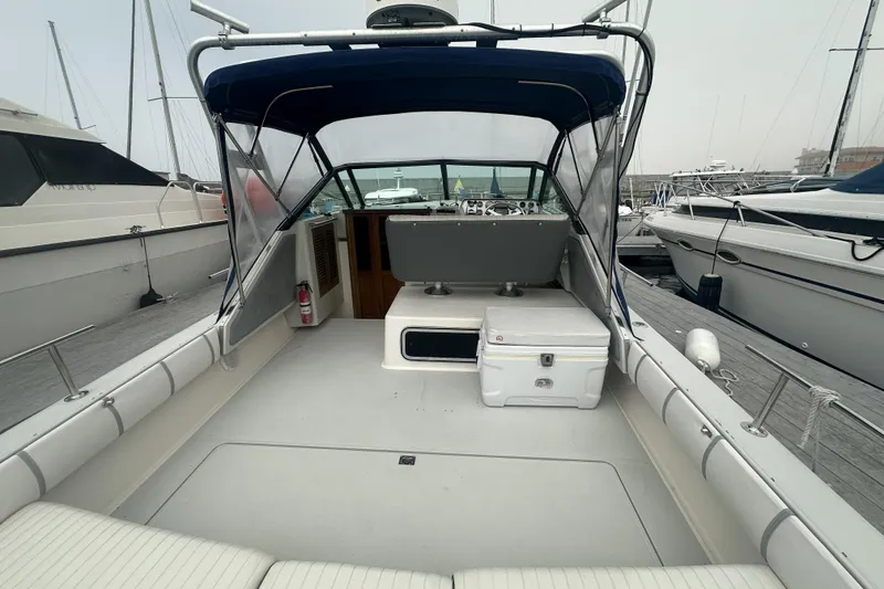 Slide: The Image of 1985 Tiara 25 boat interior with seating, canopy, and docked at marina. - 8