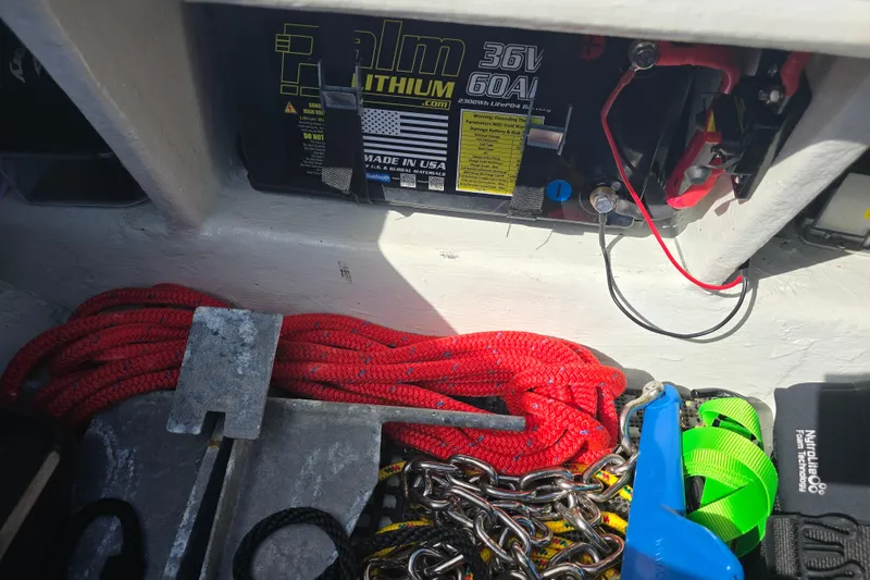 Slide: The Image of Boat storage area with battery, anchor, and ropes on a 1988 Lake & Bay Boca Grande 20. - 32