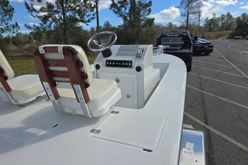 Slide: The Image of 1988 Lake & Bay Boca Grande 20 boat with dual seats and steering console in a parking area. - 33